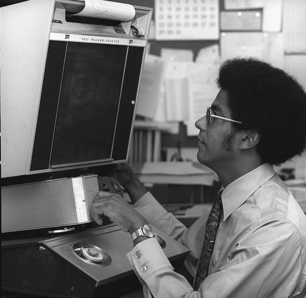 Using a microfilm reader/printer in 1976.