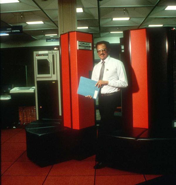 Warren standing in front of a Cray supercomputer.