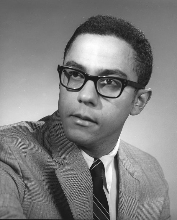 Warren Washington wearing a suit and tie and glasses.