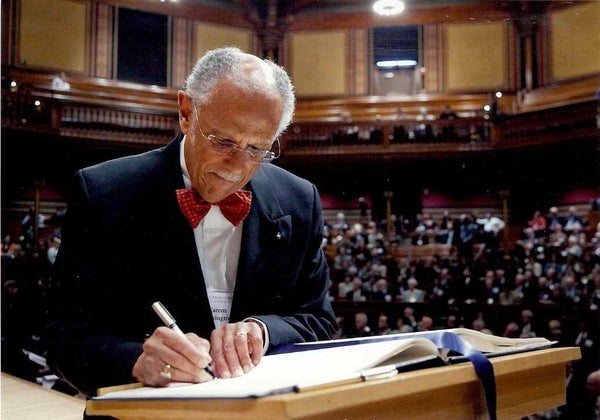 Warren signing the book making him a member of the American Academy of Arts and Sciences