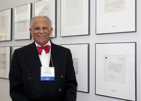 Warren in front of the American Academy of Arts and Sciences wall of acceptance letters.