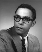 Warren Washington wearing a suit and tie and glasses.