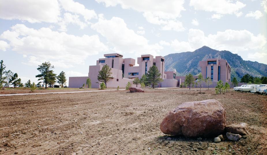 Color photo of the Mesa Lab in 1967 with foothills in the background and a rocky landscape in the foreground.