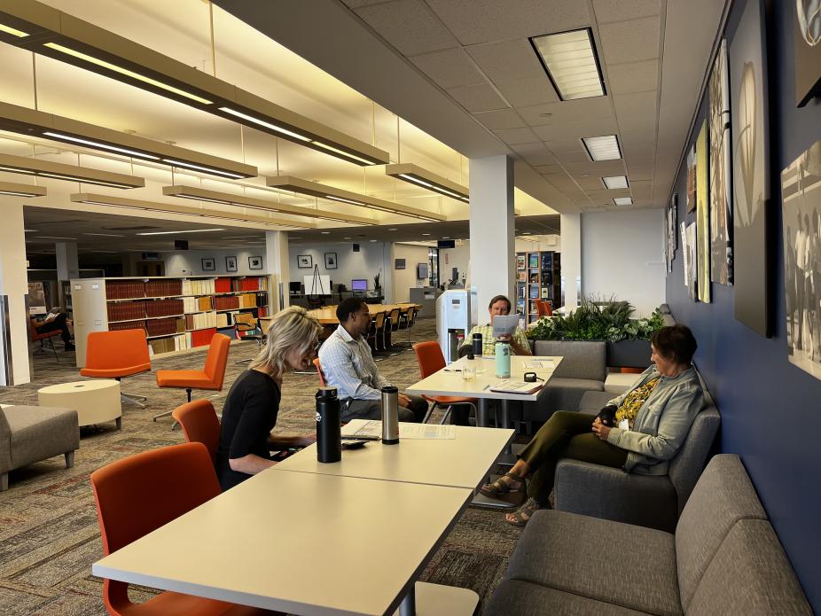 A group of people sit and talk in a meeting area of the library.
