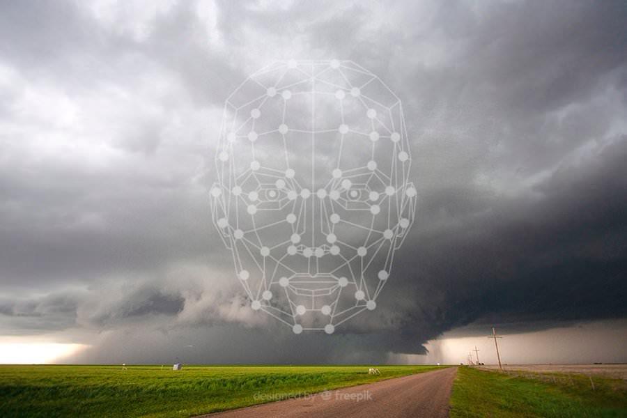 Photograph of a storm forming over a field with a digital rendering of the outline of a human face superimposed over the landscape.