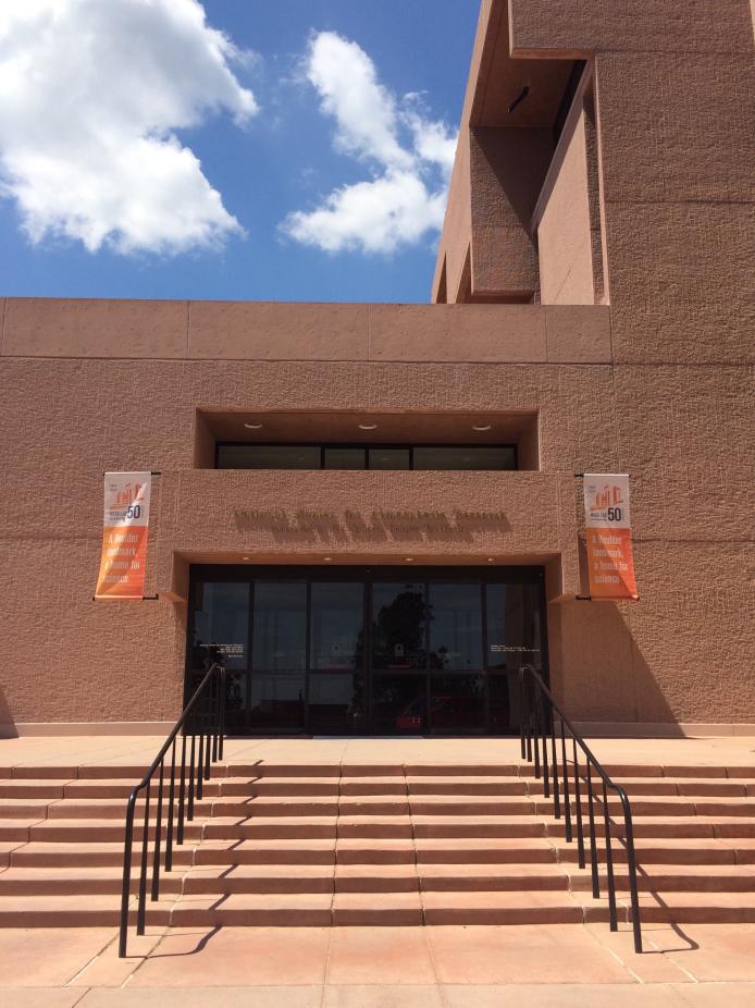 View of the front doors of the Mesa Laboratory with 50th anniversary banners flying on either side of the door.